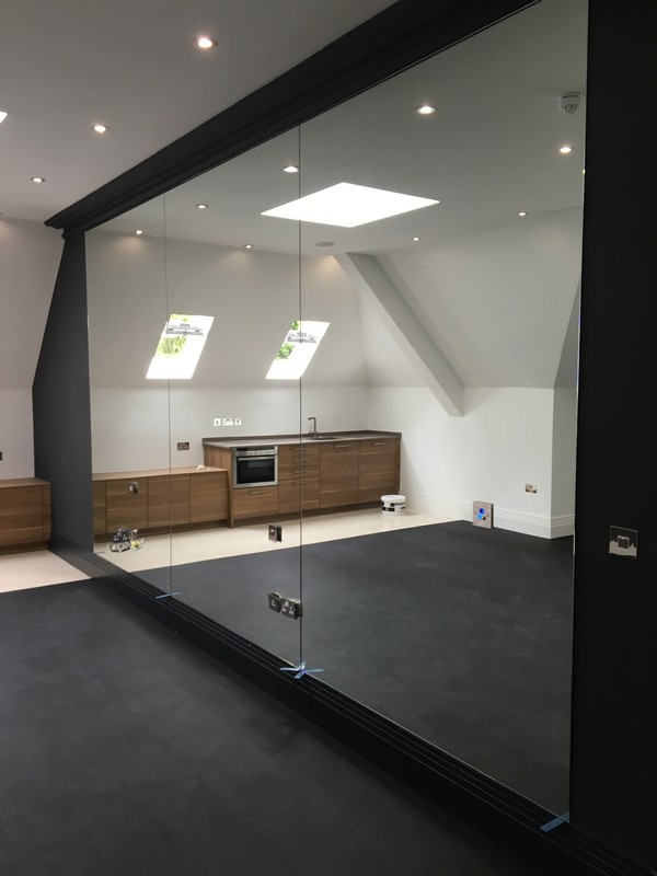 Frameless glass partition in loft conversion by Uxbridge glaziers