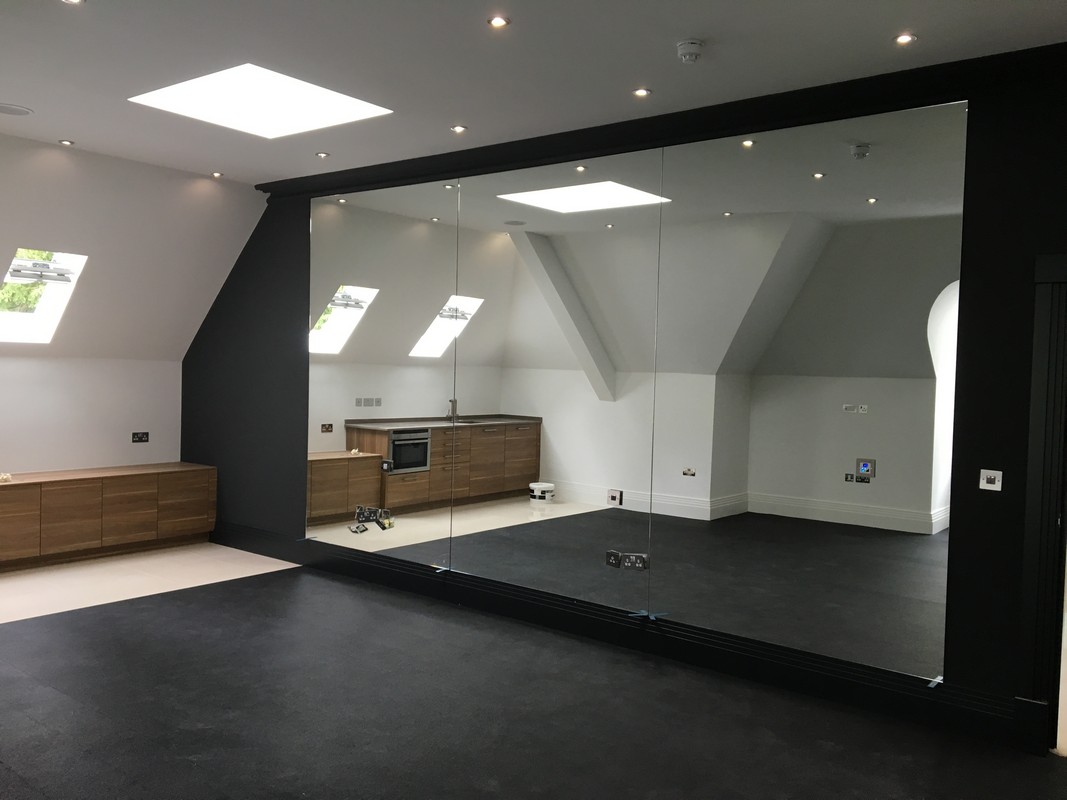 Frameless glass wall dividing loft conversion in Uxbridge